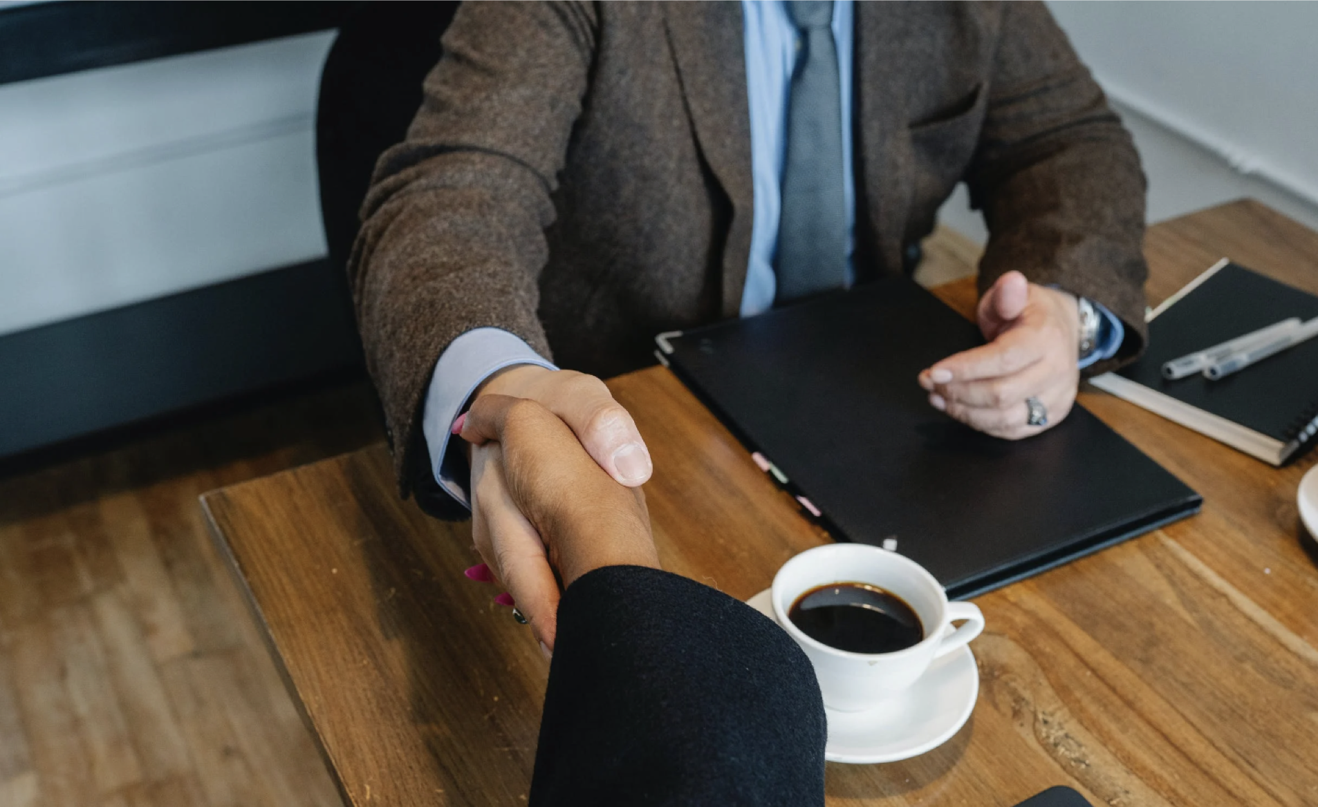 people in business suits shaking hands over a table